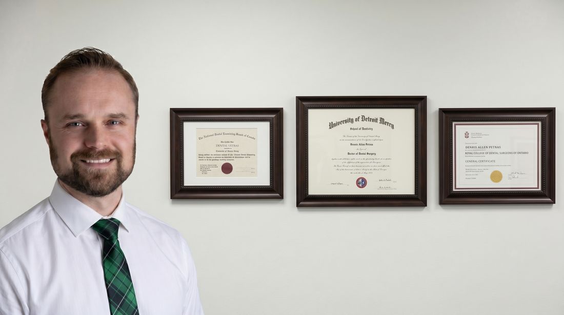 Dr. Dennis Petras with framed diplomas