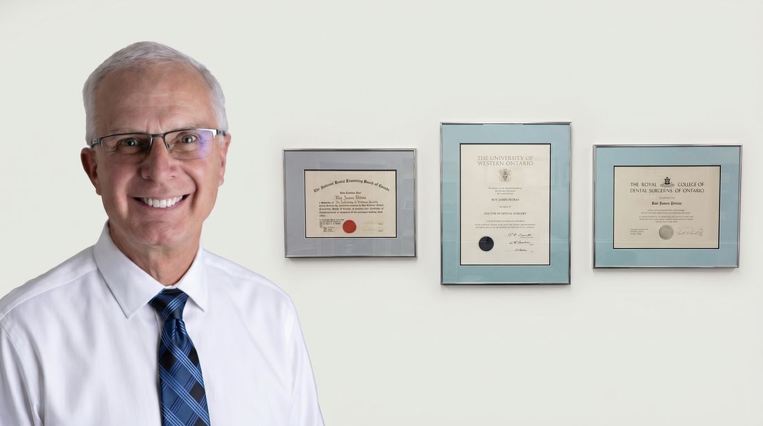 Dr. Roy Petras with framed diplomas